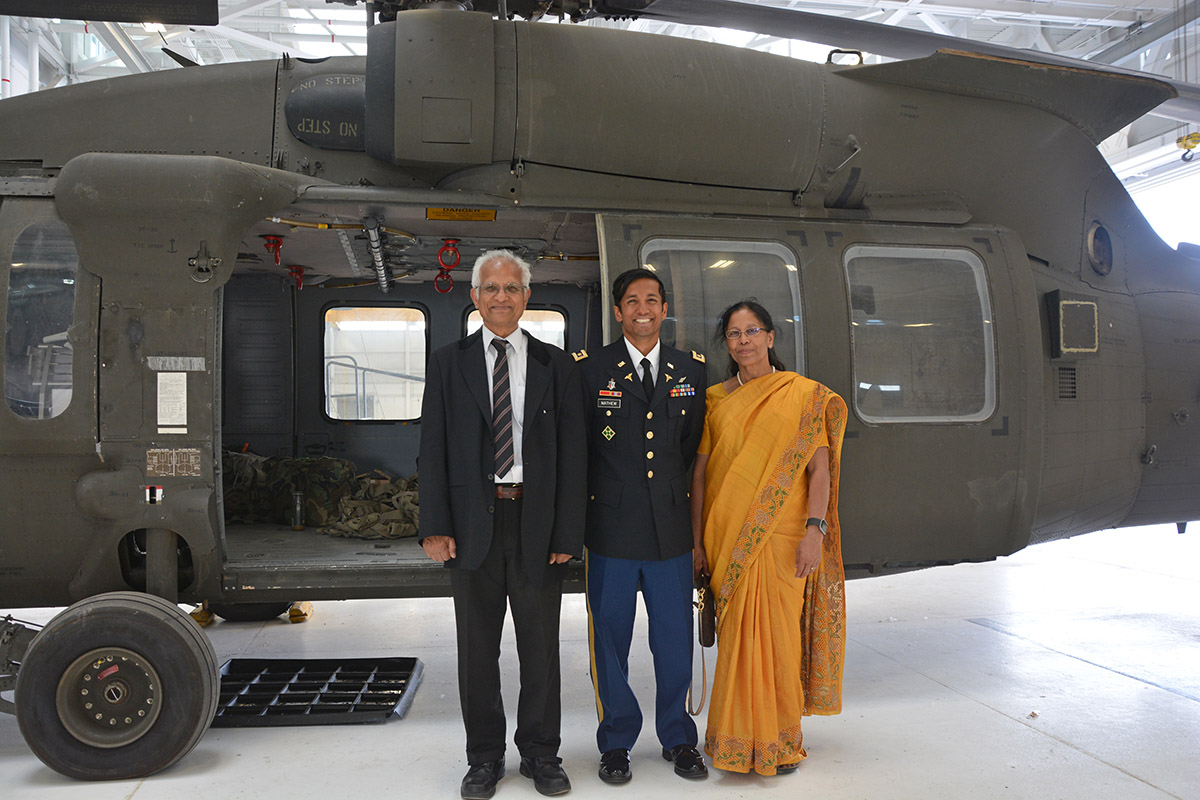 Major Dr. Jacob Mathew Jr., in fronmt of a MEDVAC Helicopter with his parents Drs Jacob and Shila Mathew